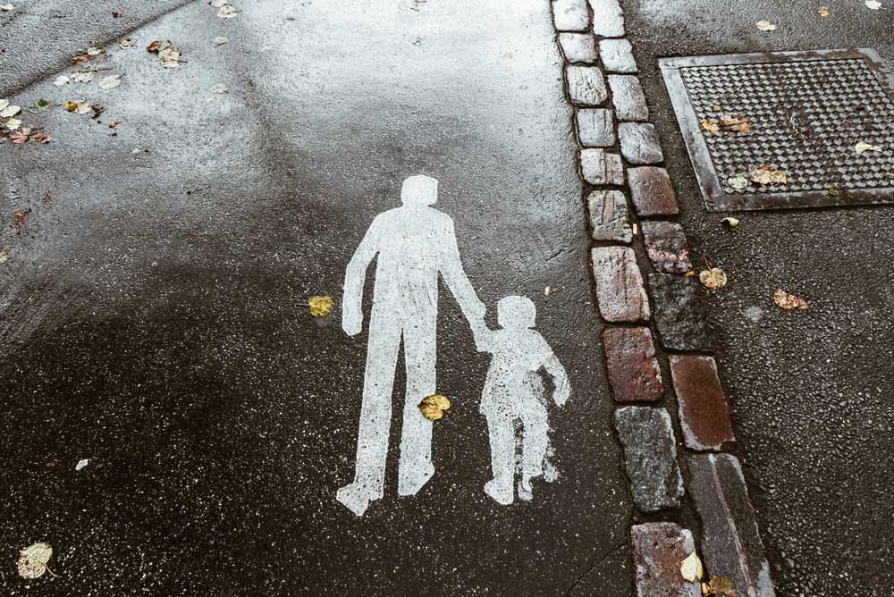 Child support modifications in high-conflict divorces—street marking of an adult and child walking together, symbolizing parental responsibility, custody considerations, and the importance of protecting children’s best interests during legal changes in support arrangements in Jacksonville and surrounding areas.