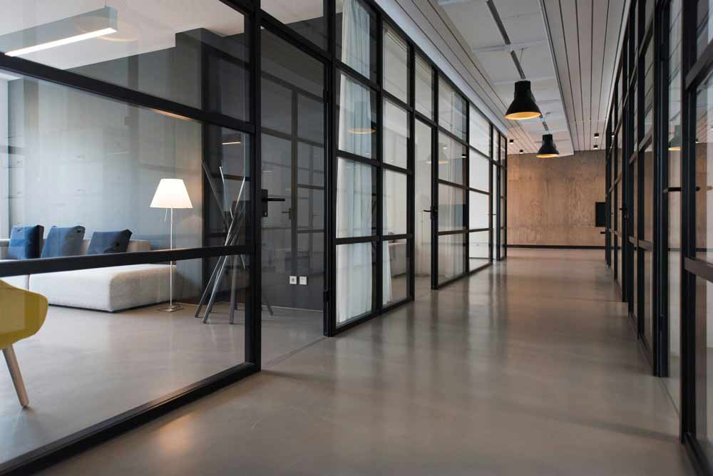 Office cleaning services in Jacksonville, FL—modern commercial office hallway with glass conference rooms, representing how to choose a professional cleaning company based on licensing, insurance, customer reviews, transparent pricing ($0.05–$0.20 per sq ft), and consistent janitorial service quality for businesses.
