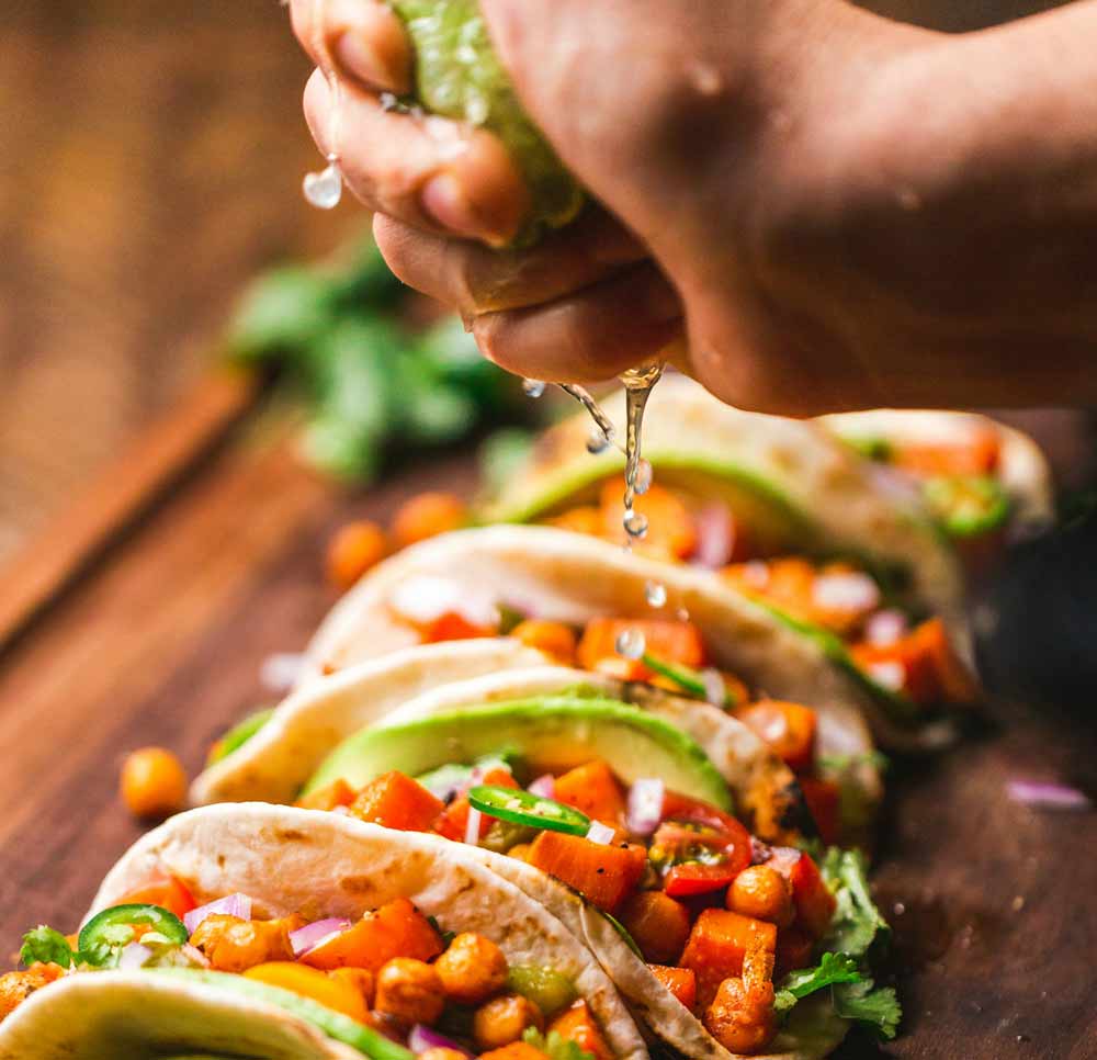 Authentic Mexican cuisine in Jacksonville—fresh tacos topped with vibrant ingredients like avocado, tomatoes, and cilantro, finished with a squeeze of lime, highlighting the importance of fresh preparation, quality ingredients, and bold flavors found in the area’s growing Mexican food scene.