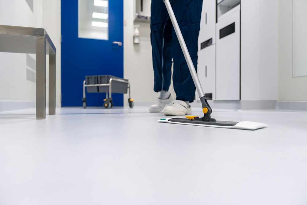 Jacksonville office cleaning frequency—professional cleaner mopping commercial hallway floor, illustrating routine janitorial services typically scheduled 1–3 times per week based on employee count, foot traffic, and business type, with increased cleaning needs for high-traffic offices and humid Florida conditions.