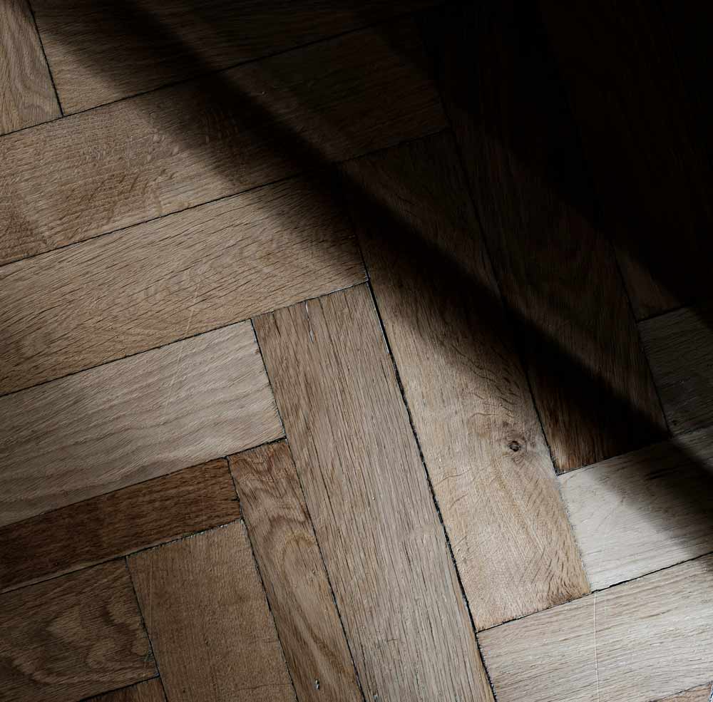 Outdated flooring transformation in Starke, FL—worn hardwood floor with visible aging and uneven tones, representing the need for modern flooring upgrades that improve home appearance, comfort, and property value.