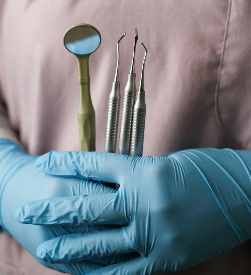 Dental implant care essentials—professional dental tools and mirror used for maintaining oral hygiene, emphasizing the importance of proper cleaning routines, regular checkups, and long-term implant health maintenance.