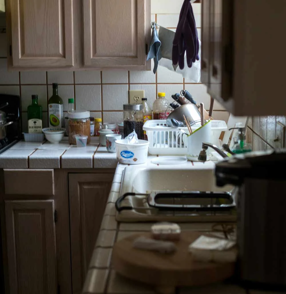 Cluttered kitchen and household mess—illustrating the real-life impact of neglecting routine cleaning, including buildup of dishes, disorganization, and the potential for increased stress, hygiene issues, and long-term maintenance costs.